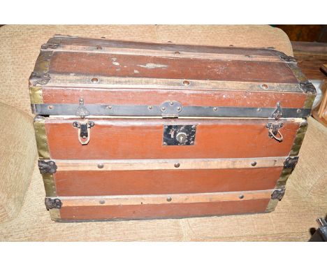 An old trunk with domed top, opening to reveal a paper lined interior, and a quantity of various fur and other hats.