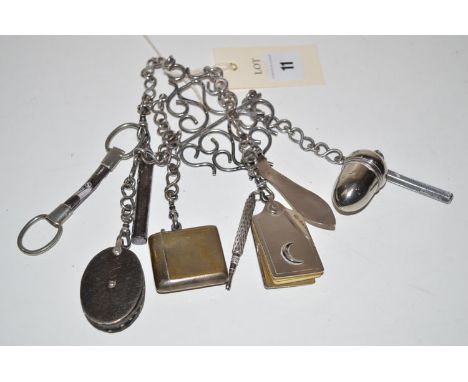 An EPNS chatelaine of scrolling design holding five chains of pin cushion, vesta case, pencil, sewing scissors, notebook, pom