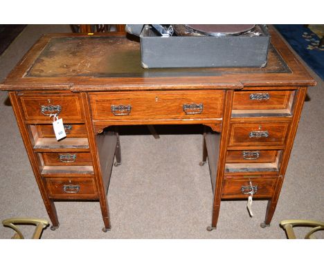 A 19th Century inlaid rosewood kneehole desk, with inset leather writing surface above a breakfront containing an arrangement