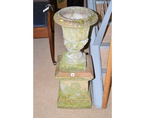 A pair of composition garden urns (slightly incomplete and damaged) on square plinth bases; together with an oval basket-shap