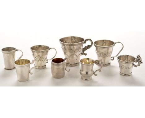 Eight assorted South American white metal cups/measures, probably Peruvian, three cups with octagonal bases and engraved foli