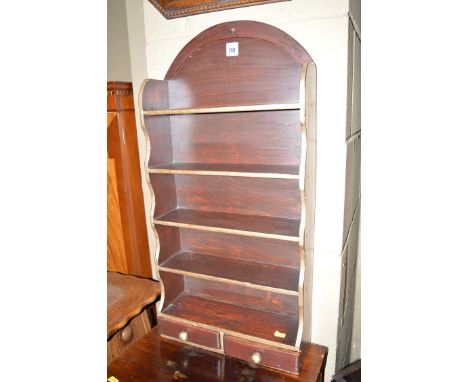 A small stained wood five-tier wall hanging open shelf unit, fitted two small shallow drawers in the base.