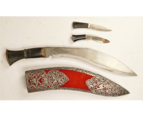 A ceremonial kukri, with two small knives, the scabbard with pierced white metal decoration, length of blade 27cm.