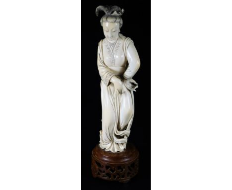 A Japanese Taisho period ivory figure, of a lady in flowing robes picked out in black with hair up, on a pierced wooden base,