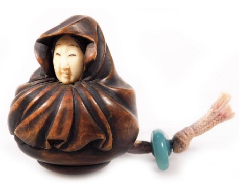 A Japanese Taisho period ivory and hardwood netsuke, carved as a lady in a shawl, with stringing and glass fastener, unmarked