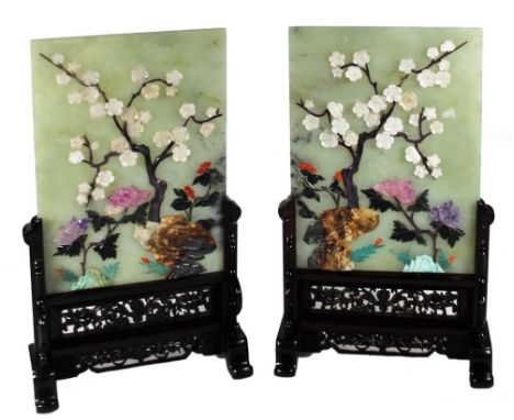 A pair of 20thC Chinese jade plaques, each of rectangular form, raised with blossoming trees and flowers, predominately in gr