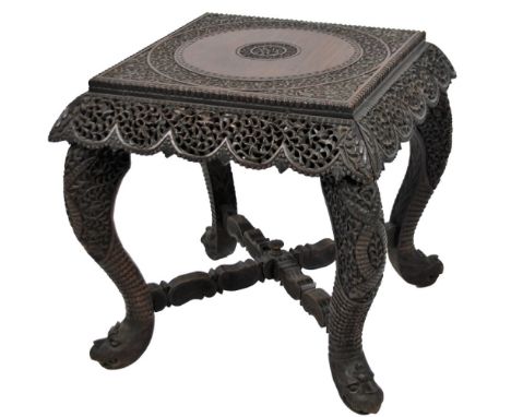 A 19thC Anglo Indian side table, probably Bombay School padouk, the heavily carved square top centred with two circles with a