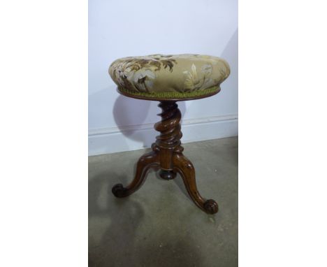 A 19th century rosewood revolving piano stool on a tapering twist column and scroll tripod base with button seat