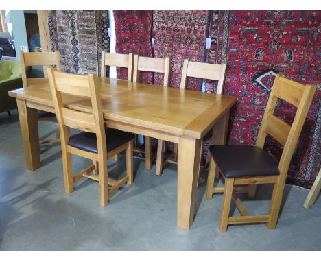 An oak extending dining table with a folding leaf and six leather seated ladder back chairs - Height 79cm x 100cm x 180cm, ex