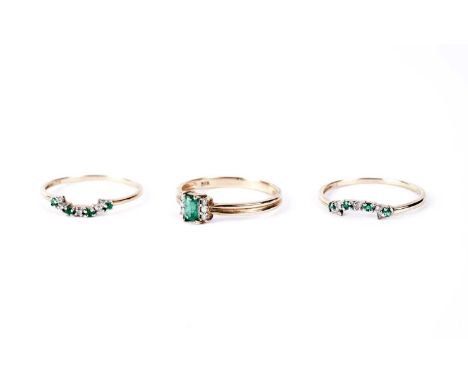 An emerald and diamond dress ring, the step cut emerald flanked by trios of round cut diamonds, in 9ct yellow gold, size Q; t
