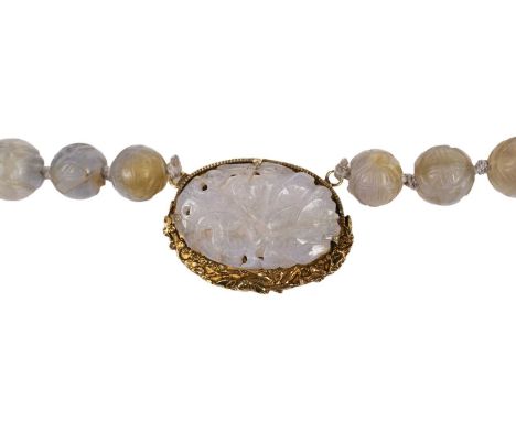 A Chinese carved soapstone (jade simulant) bead necklace, the panel with floral design in gold mount bearing character mark, 