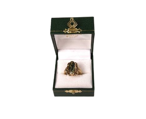A moss agate and 9ct yellow gold ring, the oval moss agate cabochon in collet mount and scroll setting, ring size N, 7.1g gro
