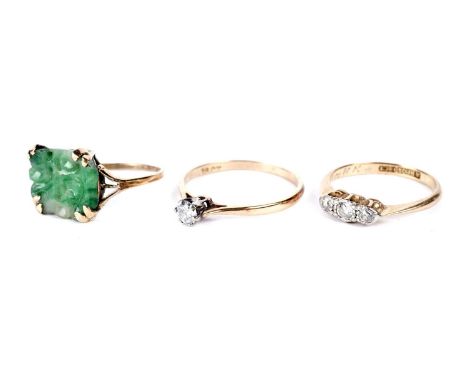 Two diamond rings, one single stone, the other three stone, in 18ct yellow gold mounts and shanks, 4.4g gross; and a jade rin