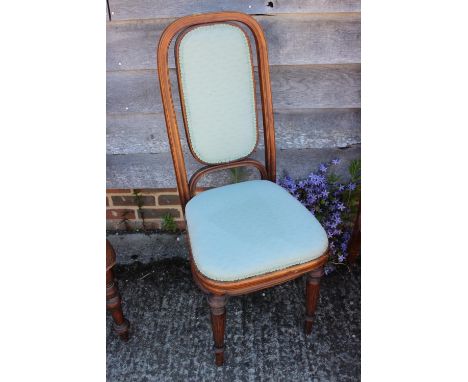 An oak framed side chair with padded back and seat, upholstered in a light blue patterned fabric, on turned and fluted suppor