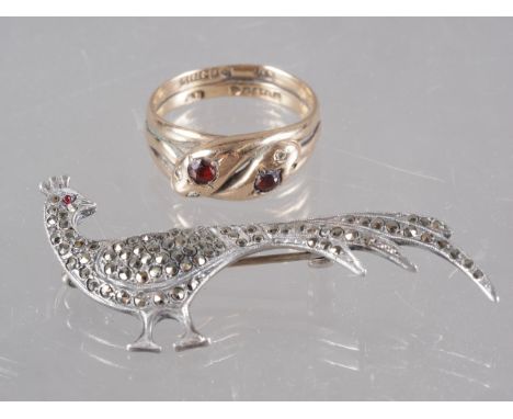 An Edwardian 9ct gold, diamond and garnet double snake ring, Chester 1902, size S, 5g, and a silver and marcasite peacock bro