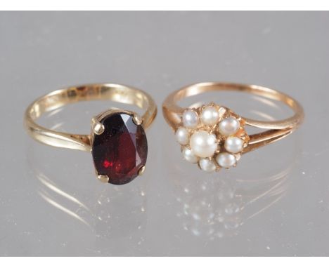 A yellow metal and seed pearl cluster ring, size N/O, 2.2g, and a 9ct gold and garnet single stone ring, size L/M, 3g 