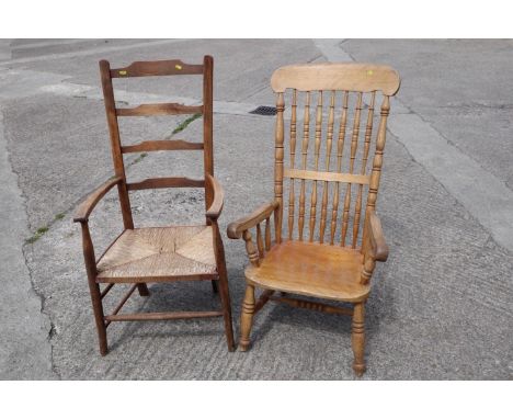 An Arts &amp; Crafts ladder back chair with rush envelope seat and a spindle back Windsor farmhouse elbow chair (cut down) 