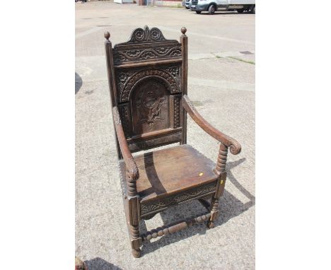 An oak wainscot chair of 17th century design with arch top panel back, on turned and stretchered supports 