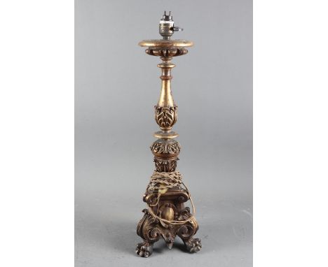 A carved gilt wood candlestick, now a table lamp, 17” high, and two similar smaller candlesticks 