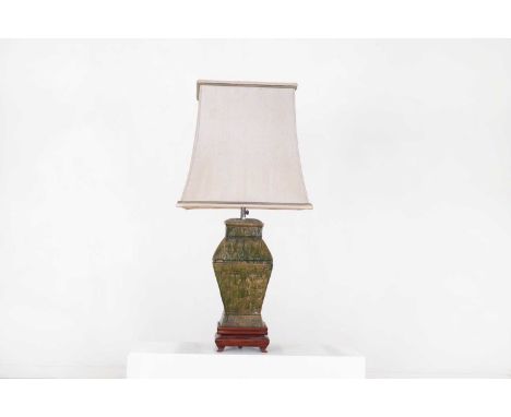 An Egyptian Revival vase lamp, 20th century, of green-glazed terracotta and raised on a wooden stand, with a silk shade,23cm 