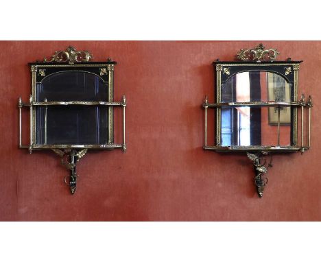 A pair of parcel gilt wall shelves mid 19th century, with scrolled pediments, above mirrors with beaded borders, to two shelv