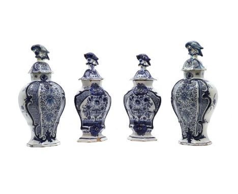 A Delftware pottery part-garniture, 19th century, comprised of two pairs of lidded baluster vases, painted in blue and white 