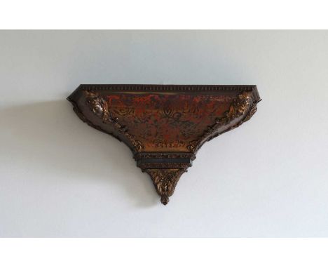 A boulle work clock bracket late 19th century, the corners decorated with masks leading to a foliate base,68cm wide26cm deep4