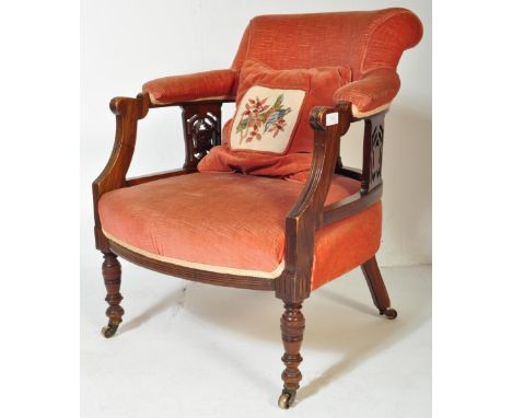 A 19th century Victorian mahogany tub armchair. Raised on turned legs with overstuffed seat and back rest having pierced gall