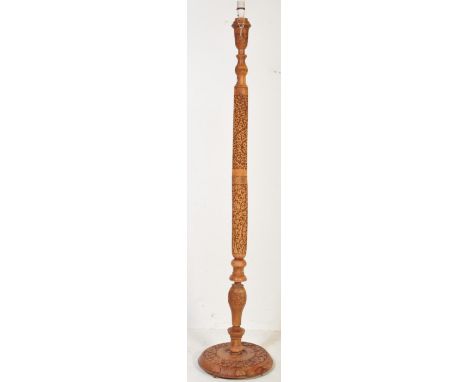 A mid century Chinese carved hardwood standard lamp raised on carved leaf circular base with carved foliate leaf worked colum