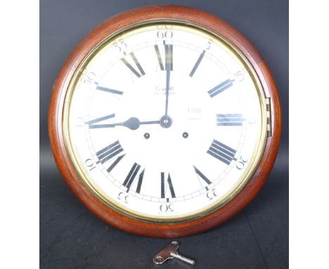 A 20th century Comitti of London mahogany cased station clock. Mahogany surround with brass bezel having white dial with roma