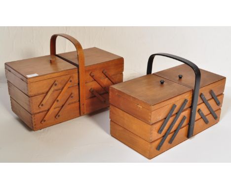 A pair of retro vintage mid 20th Century light wood cantilever sewing boxes with carrying handles atop and contents inside. L