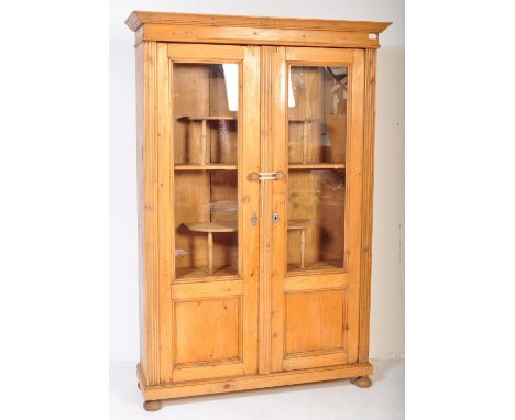 A large 20th century country pine French kitchen armoire display cabinet. The cabinet having pediment top over twin glazed do