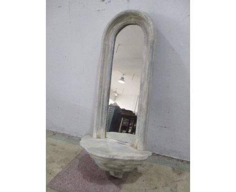 A painted mirror with scallop shaped shelf under