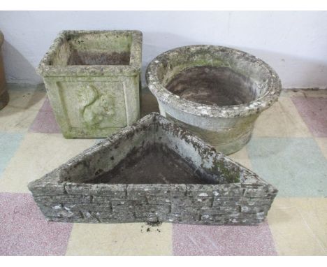 A corner concrete planter, along with two others