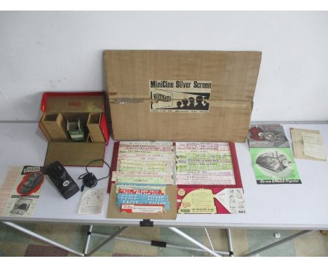 A boxed Minicine Projector with a selection of films, silver screen and original instructions