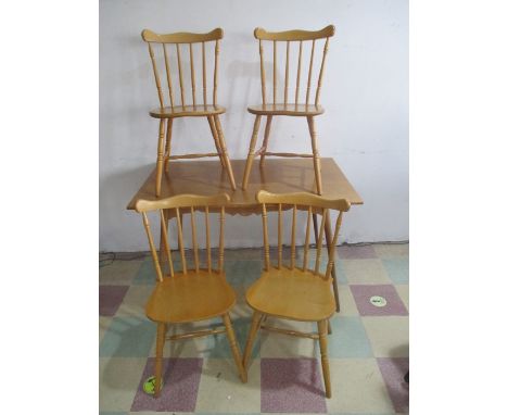 A light oak effect dining table with four chairs