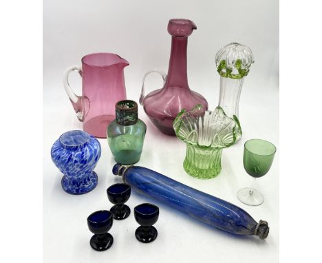 A collection of antique coloured glass including large cranberry jug, blue glass rolling pin etc. 