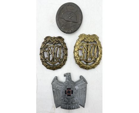 A German WWII wound badge marked to reverse 107, two DRL sports badges along with an NSKOV cap eagle