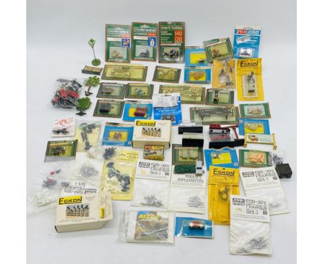 A collection of model railway OO gauge scenery including passengers, animals. sewage pipes. signals. switch boxes, telephone 