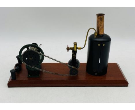 A vintage live steam engine with vertical boiler, mounted on a wooden plinth - overall length 37cm