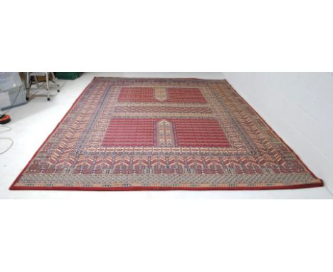 An Eastern style red ground carpet. some fraying to one edge 366cm x 277cm, 12ft x 9ft  