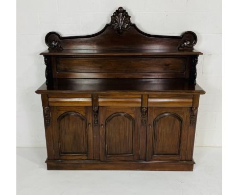 A Victorian style mahogany chiffonier with scrolling raised panel above three drawers and cupboard doors with removeable top,