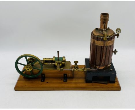 A vintage live steam engine with vertical boiler, mounted on a wooden plinth - overall length 46cm