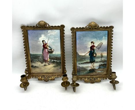 A pair of vintage brass framed hand painted ceramic tiles with moveable candle sconces, both depicting women working on the s