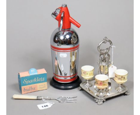 An Edwardian silver bread fork with a mother-of-pearl handle 21.5cm long, Sheffield 1906; a silver-plated egg cruet; &amp; a 