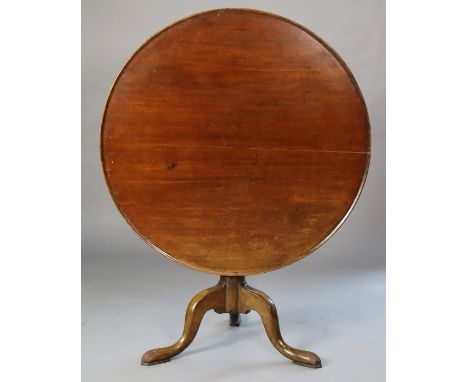 An 18th century mahogany tripod table, the circular tilt-top with bird-cage support, on a turned centre column &amp; three ca