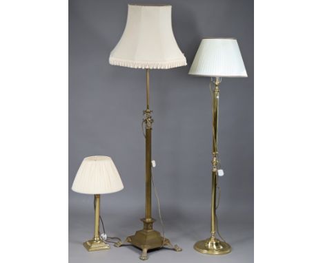 A brass Corinthian-style telescopic standard lamp on a stepped square base with lion-paw feet; together with another brass st