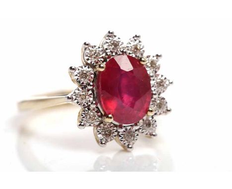 RUBY AND DIAMOND CLUSTER RINGset centrally with an oval ruby, surrounded by a row of brilliant cut diamonds, in nine carat ye