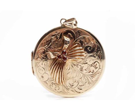 LARGE NINE CARAT GOLD LOCKETof circular form, with an overlaid garnet set bow motif, 19g