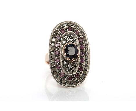 UNUSUAL SAPPHIRE, RUBY AND DIAMOND RINGthe large bezel set with a central oval sapphire, the surrounding setting with round r